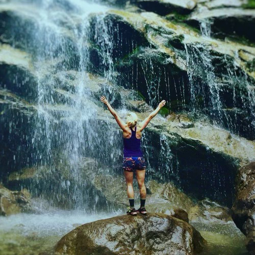 woman standing near waterfall
